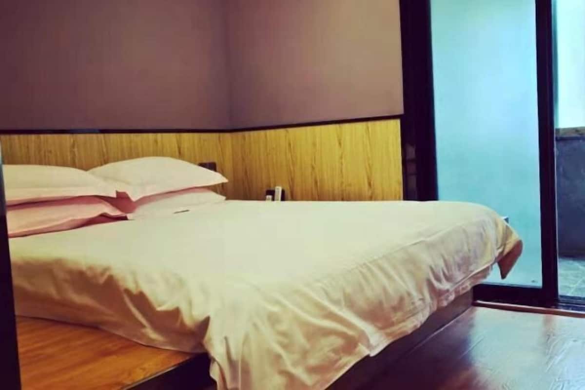 Ein Bett mit Holz-Kopfteil, einer weißen Matratze und Kissen.