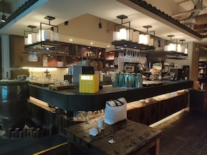 A bar area with a counter, hanging lights, and a coffee machine. - Ji Hotel (Shanghai)