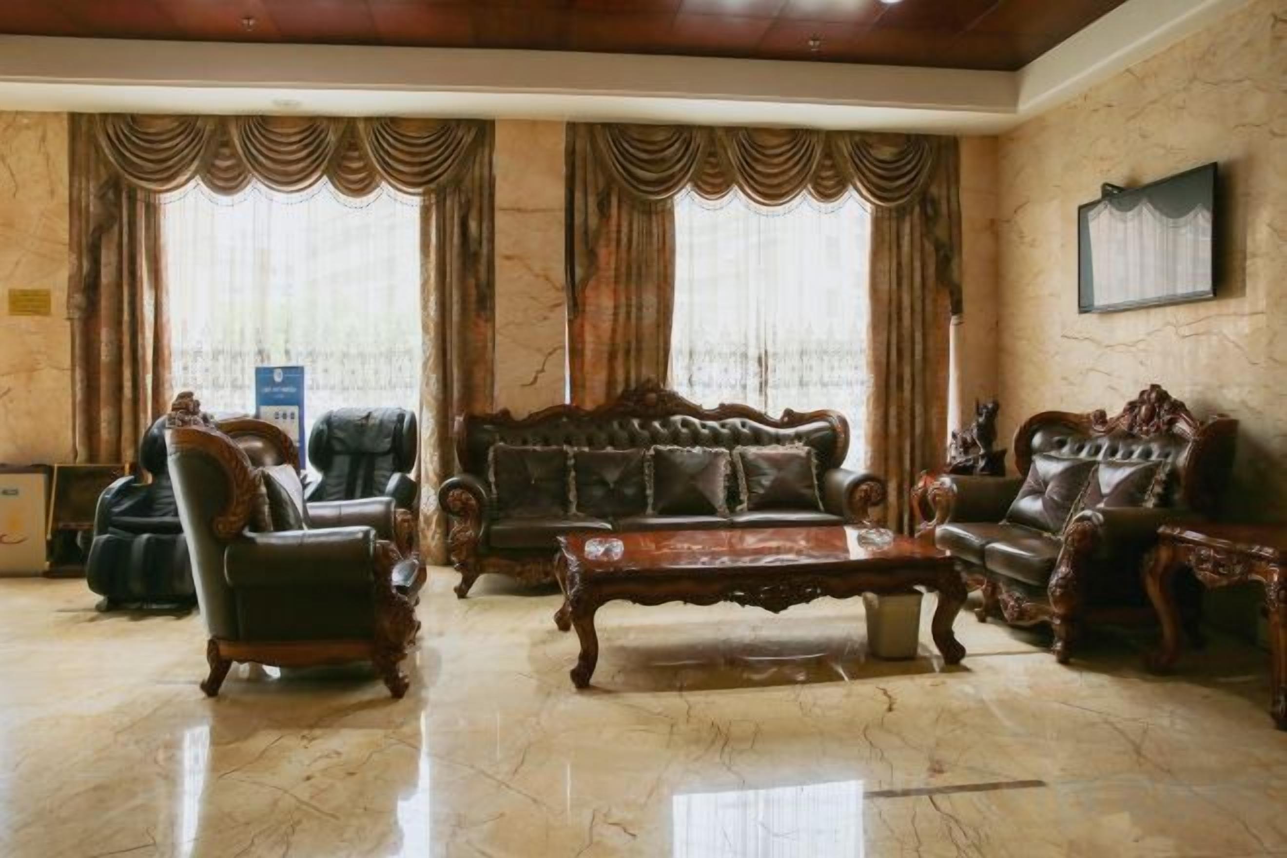 A spacious living room with a large sofa, two armchairs, and a coffee table.