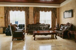 Una sala de estar amplia con un sofá grande, dos sillones y una mesa de centro.