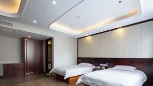 Quarto de hotel com duas camas, um guarda-roupa de madeira e um espelho grande.