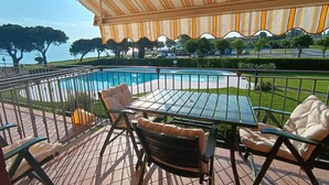 Eine Terrasse mit Pool, Gartenmöbeln und Meerblick.