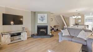 A living room with a fireplace, a sofa, a coffee table, and a TV. - 103 Golfmaster- 2 Bedroom Townhouse in Shipyard Ocean Front Community. Golf & Lagoon View Sleeps 6 (Hilton Head Island)