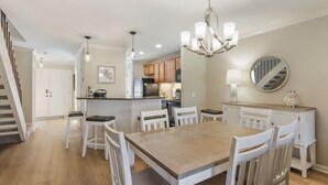 A spacious kitchen with a central island, white cabinetry, and a chandelier. - 103 Golfmaster- 2 Bedroom Townhouse in Shipyard Ocean Front Community. Golf & Lagoon View Sleeps 6 (Hilton Head Island)