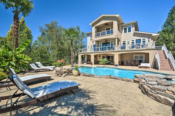 A two-story house with a swimming pool, outdoor seating, and a staircase leading to the upper level. - Luxe Getaway w/ Riverfront Views in Grants Pass! (Grants Pass)