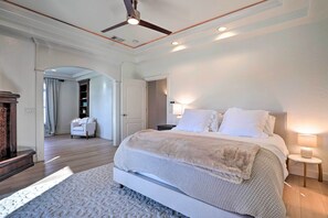 A spacious bedroom with a large bed, a ceiling fan, and a nightstand with a lamp. - Luxe Getaway w/ Riverfront Views in Grants Pass! (Grants Pass)