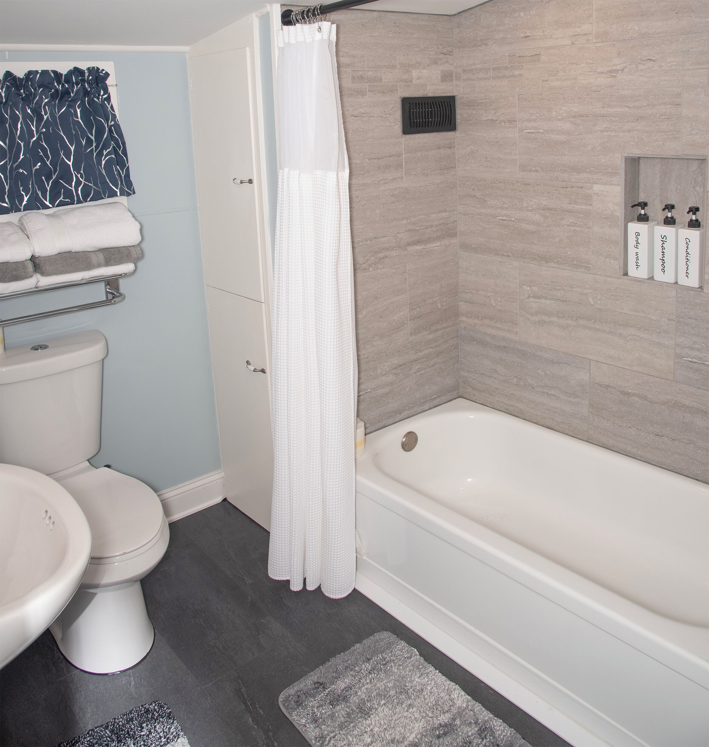 A bathroom with a toilet, bidet, bathtub, and a shower curtain.