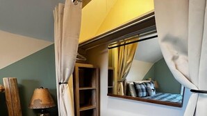 A cozy room with a wooden bench, a small table with a lamp, and a mirror on the wall. - TH3-Updated Apartment Downtown Munising, Walk to Attractions & Lake Superior (Munising)