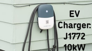 An EV charger labeled J1772 with a 10kW capacity attached to a light green building. - TH3-Updated Apartment Downtown Munising, Walk to Attractions & Lake Superior (Munising)