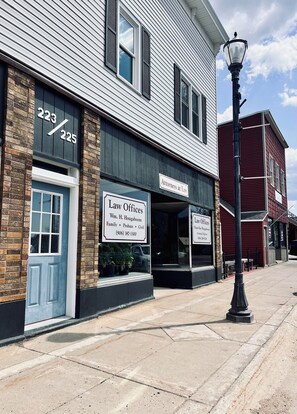 A two-story building with a sign for 'Law Offices' and 'Attorneys at Law' on the ground floor.