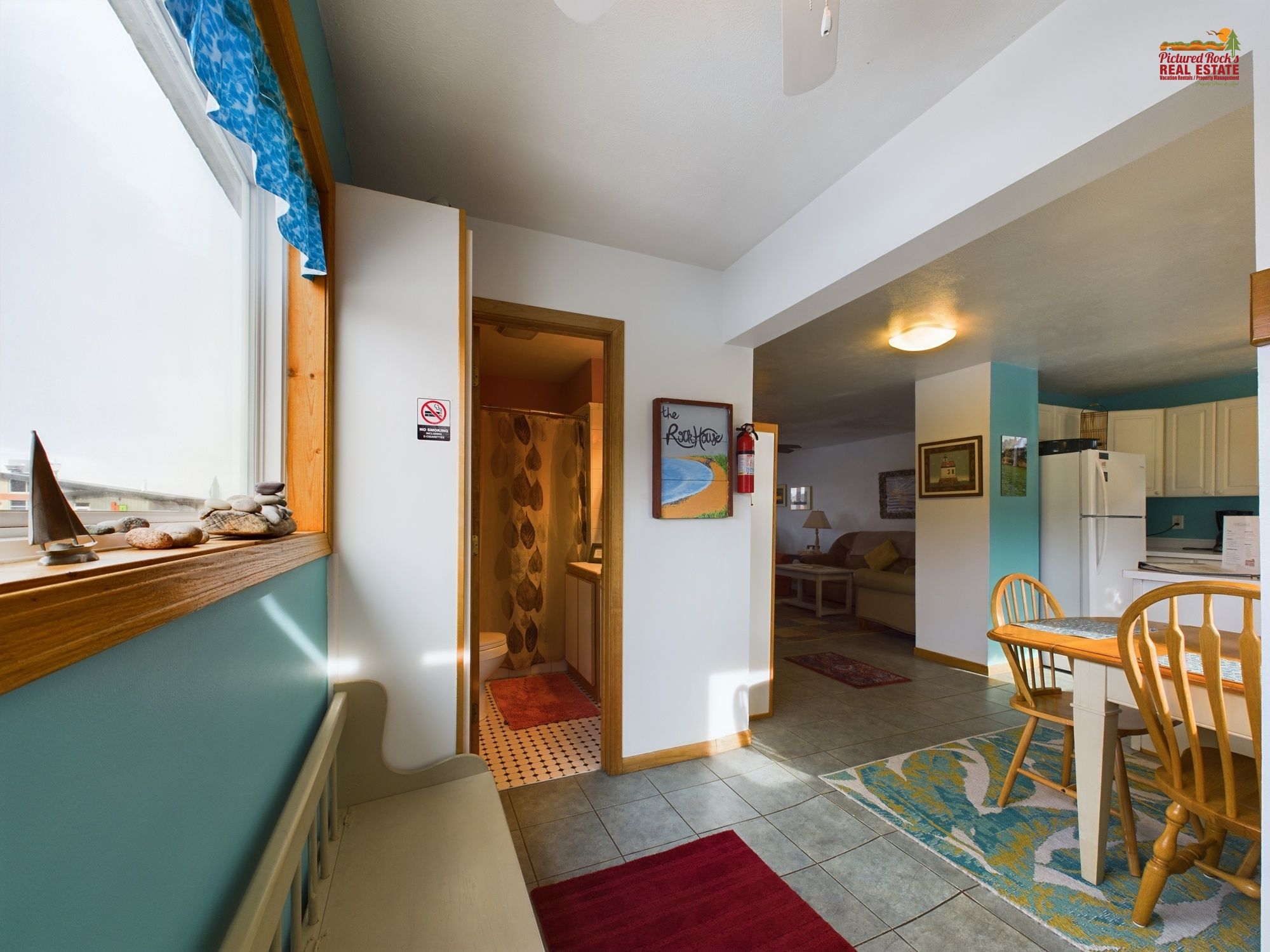 Un espace de vie compact comprenant une kitchenette, un coin repas et une salle de bain.