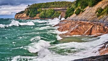 Un paisaje costero con acantilados rocosos y olas rompiendo contra la orilla.