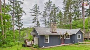 A house with a stone chimney, a front porch, and a small deck.