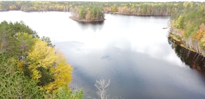 Un lac paisible, entouré d’une forêt dense aux couleurs automnales.