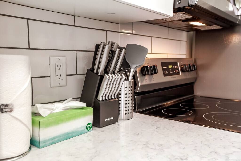 A kitchen with a stove, a knife block, and a box of tissues.