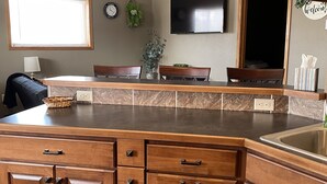 A kitchen with a large island, wooden cabinets, a built-in sink, and a ceiling fan. - Store that boat inside!  Blocks to boat ramps/Marina & Restaurant (Chamberlain)