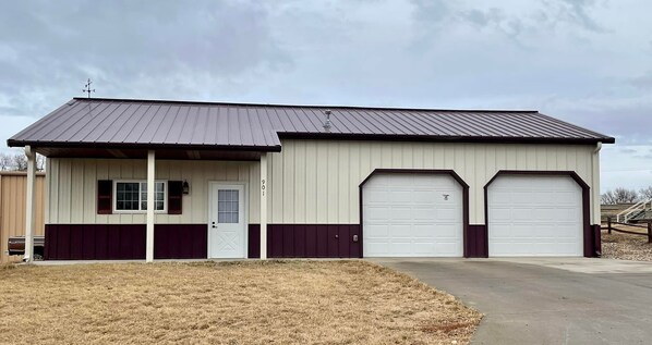A single-story building with a metal roof, two garage doors, and a small porch with a door. - Store that boat inside!  Blocks to boat ramps/Marina & Restaurant (Chamberlain)