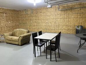A room with a beige sofa, a table with chairs, and a projector mounted on the wall. - Store that boat inside!  Blocks to boat ramps/Marina & Restaurant (Chamberlain)