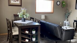 A dining area with a table, chairs, and a wine rack. There is a sofa and a TV in the background. - Store that boat inside!  Blocks to boat ramps/Marina & Restaurant (Chamberlain)