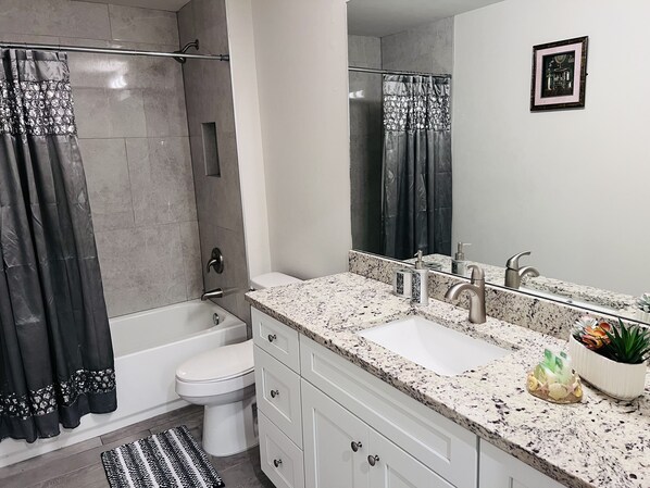 A modern bathroom with a bathtub, toilet, and sink.