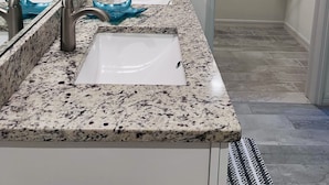 Un baño con dos lavamanos, un espejo y un perchero para toallas.