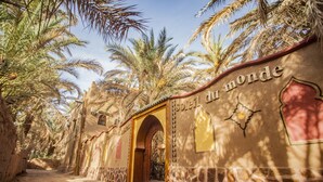 A building with a sign reading "Hotel du Monde" and an archway entrance. - Guest house in oasis amazrou Zagora south est Maro (Amazraou zagora)