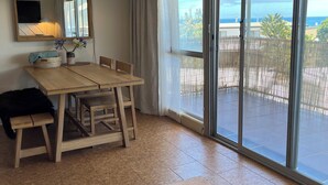 Un comedor con una mesa y sillas de madera, un espejo grande y vistas al exterior a través de un ventanal corredero.
