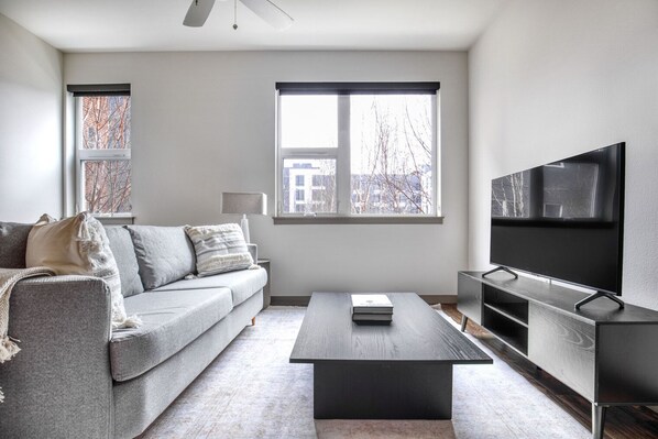 Relax in this stylish living room with a sofa, coffee table, and flat-screen TV.