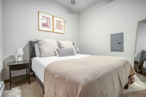 Relax in a serene space with a large bed, bedside table, and framed artworks.