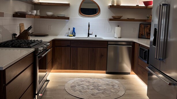 A modern kitchen with wooden cabinets, stainless steel appliances, and a central island.