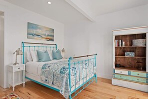 Une chambre à coucher avec un lit, une table de chevet, une lampe et une bibliothèque.