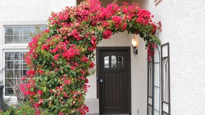 Una casa con una puerta negra y una pared exterior blanca.