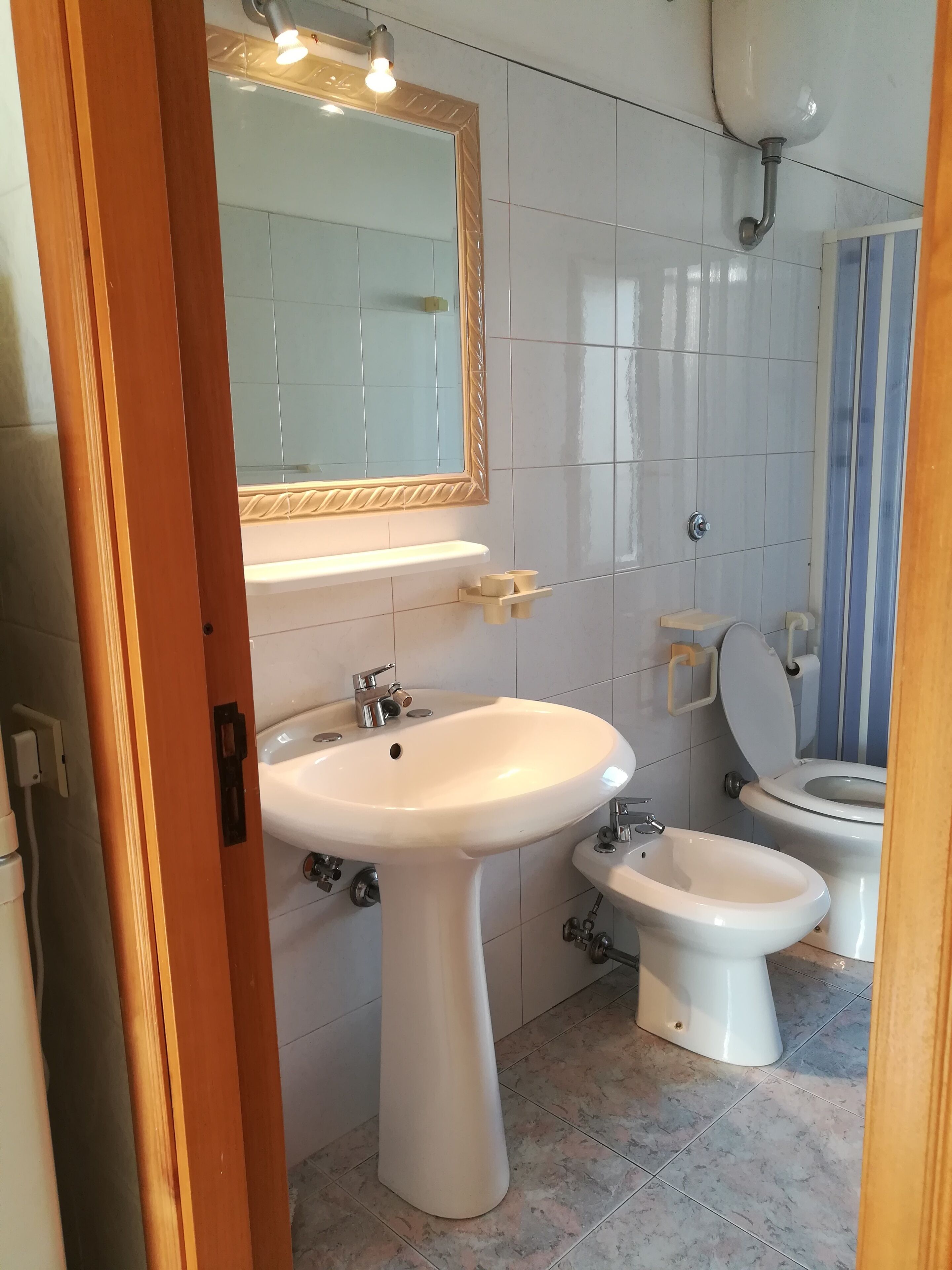 Ein Badezimmer mit einem Standwaschbecken, einer Toilette und einem Bidet.