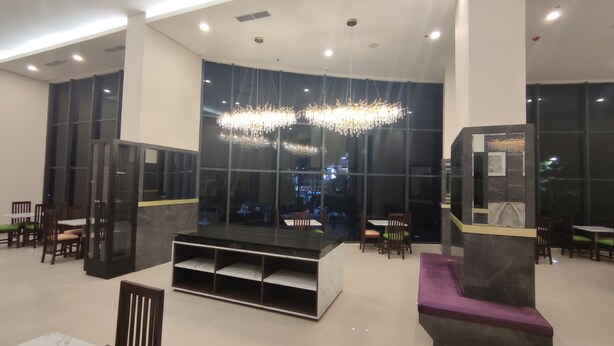 A modern lobby with a central seating area, large windows, and a chandelier. - Agogo Downtown (Surabaya)