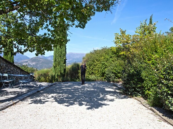 Un sendero de grava que conduce a un muro de piedra con área de estar al aire libre.