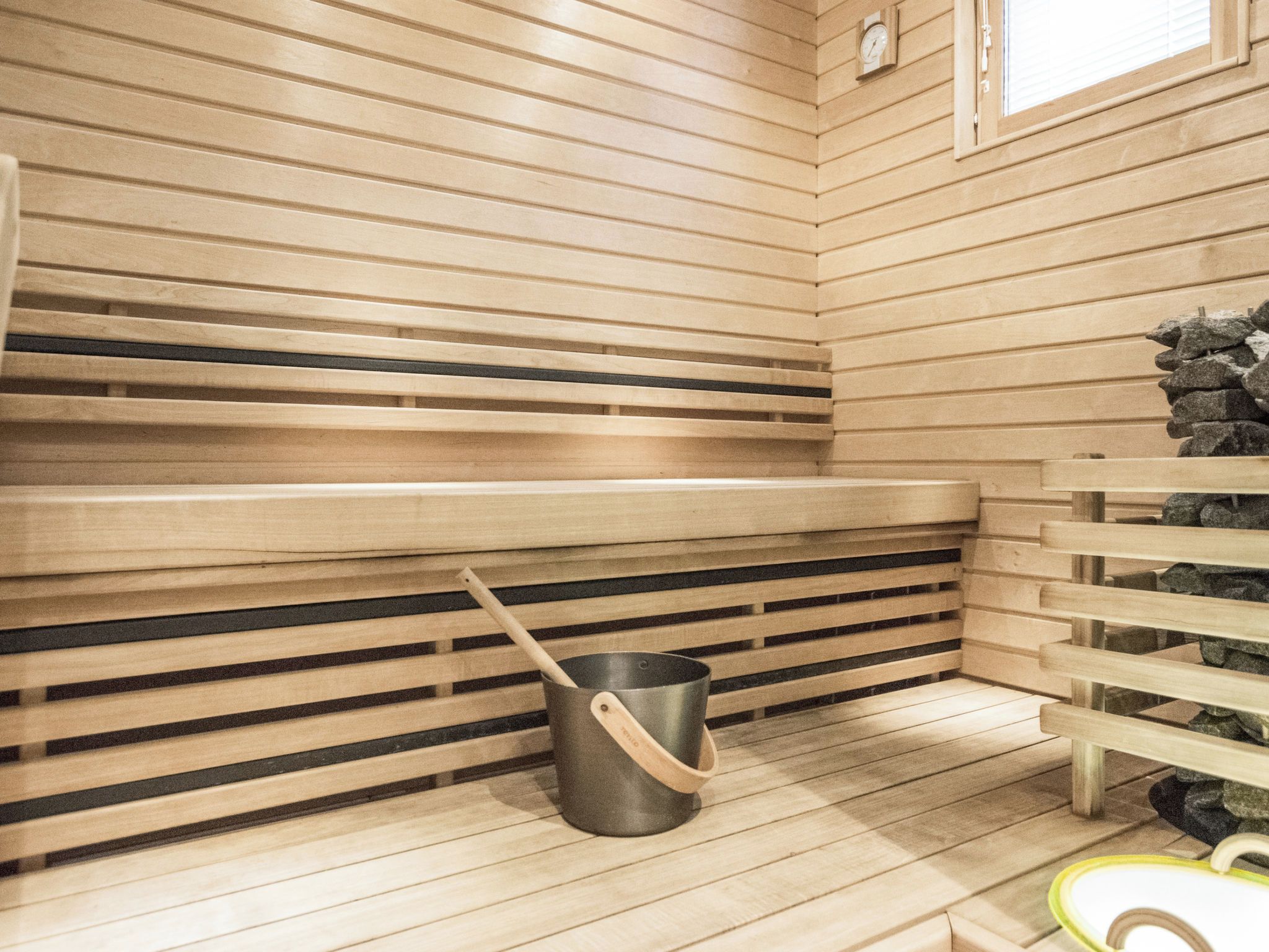 Een sauna met houten banken en een stenen muur.
