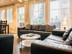 A cozy living room with a leather sofa, a coffee table, and a chair.