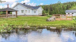 A house with a large lawn, a wooden deck, and a small pond. - Villa lahti by Interhome (Leppävirta)