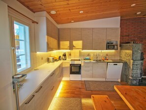 Une cuisine moderne avec des meubles en bois, un four encastré, un four à micro-ondes et un lave-vaisselle.