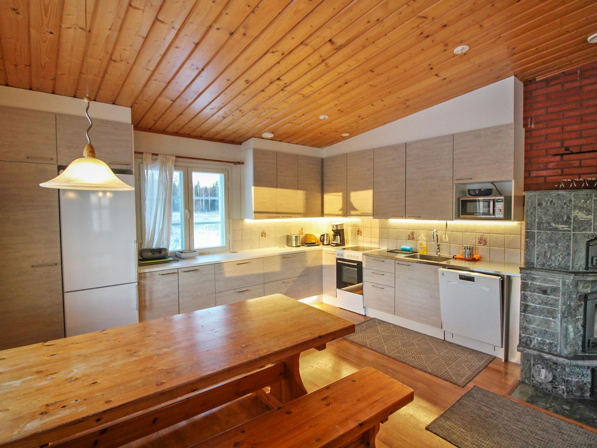 Een koelkast, een magnetron, een vaatwasser, kookgerei, borden en bestek