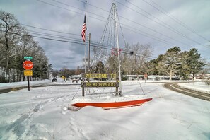 Een besneeuwde weg met een stopbord, een Amerikaanse vlag en een verwelkomingsbord voor Beachwood.