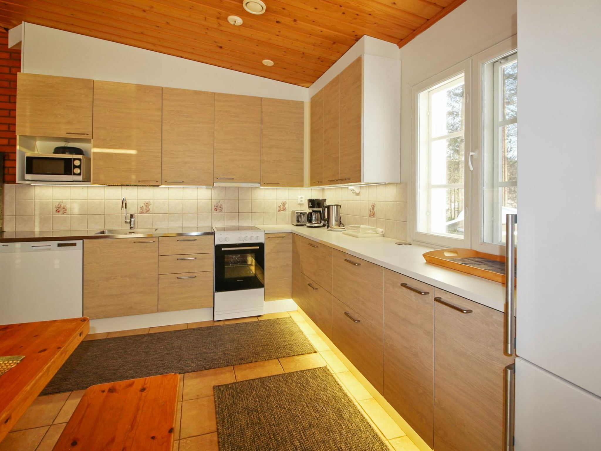 Een koelkast, een magnetron, een vaatwasser, kookgerei, borden en bestek