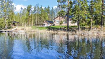 Järvenrantatontti, jossa on talo, laituri ja ympäröivä metsä.