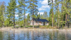 Una casa rodeada de bosque y lago.