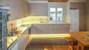 A modern kitchen with wooden cabinets, a stainless steel sink, and a window providing a view of the outdoors.