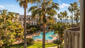 Ein Resort mit Poolbereich, Palmen und Blick auf den Ozean.