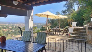 A patio with a table and chairs, an umbrella, and a view of the landscape. - Villa Schenk - Urb Rio de Oro, Calonge, Catalonia (Calonge)