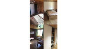 A bedroom with a bunk bed, a small desk, and a window with curtains.