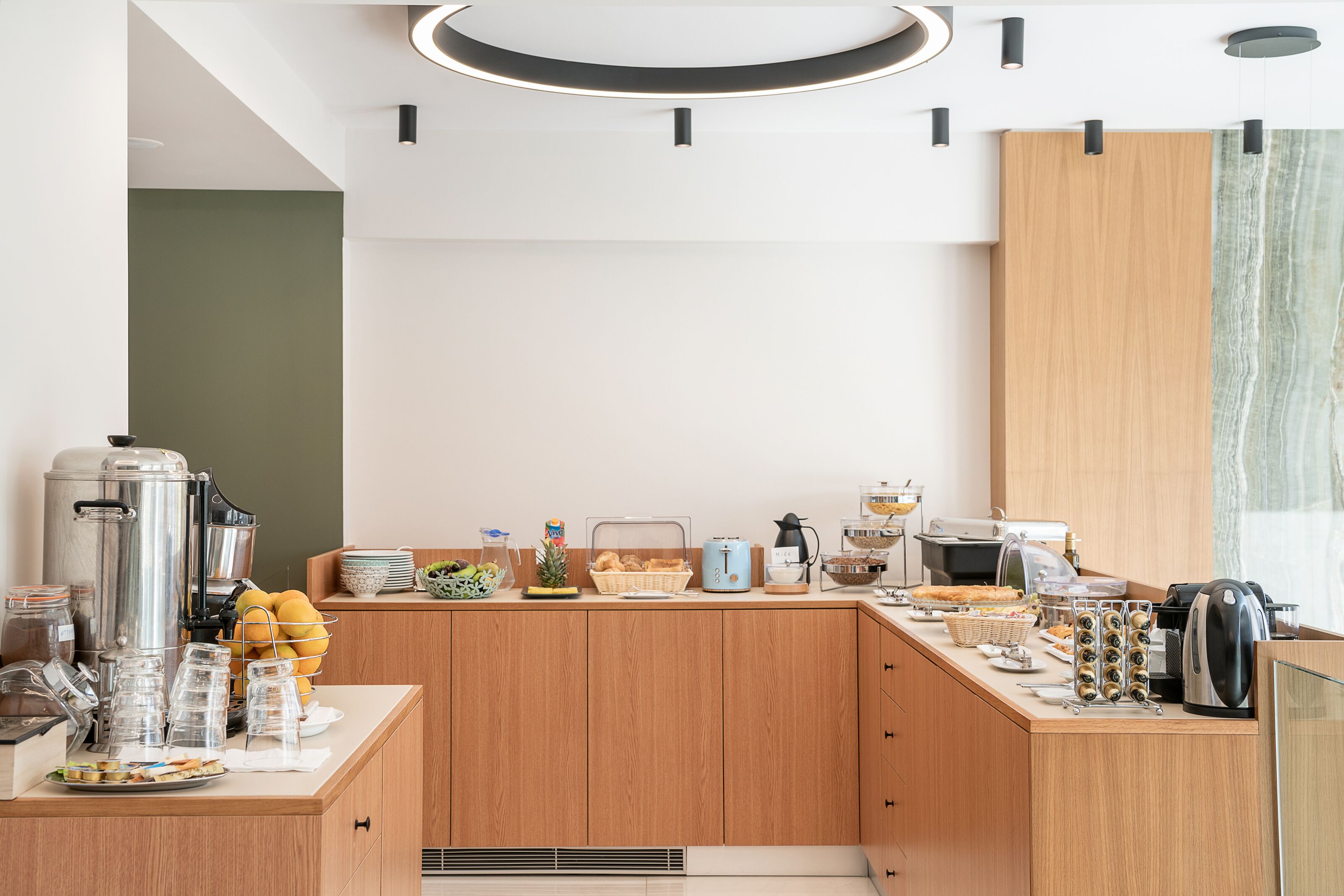 Una cocina moderna con una estación de café integrada, un frutero y una variedad de alimentos para el desayuno.