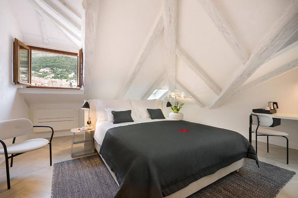 Un dormitorio moderno con una cama grande, un escritorio y una silla.